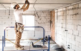 Homme sur chantier rénove plafond